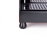 Black ash foot sliding over the stock rubber foot of a Gaggia Classic