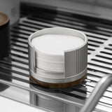 Silver filter paper holder with the walnut lid removed, on an espresso machine drip tray