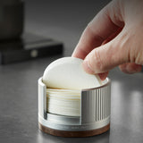 Hand pulling a 58 mm paper filter from the silver aluminum holder