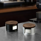 Black and silver filter paper holders, loaded, on a steel counter